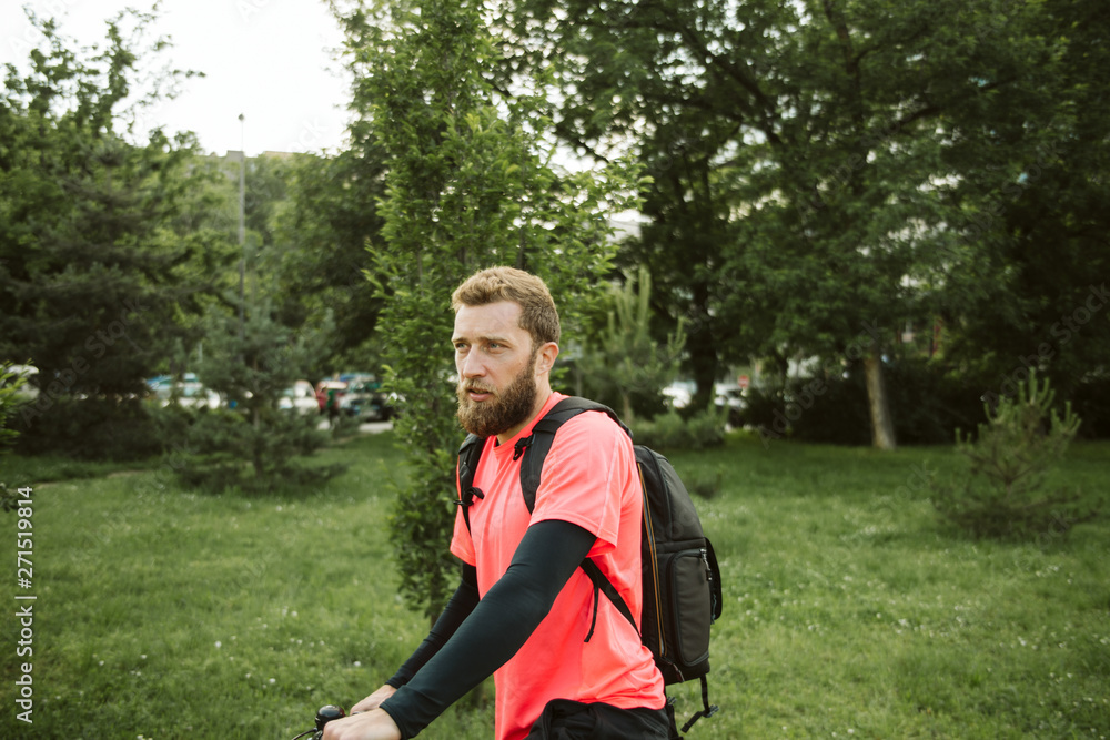A young and handsome man riding a bicycle in the park A young and handsome man riding a bicycle in the park