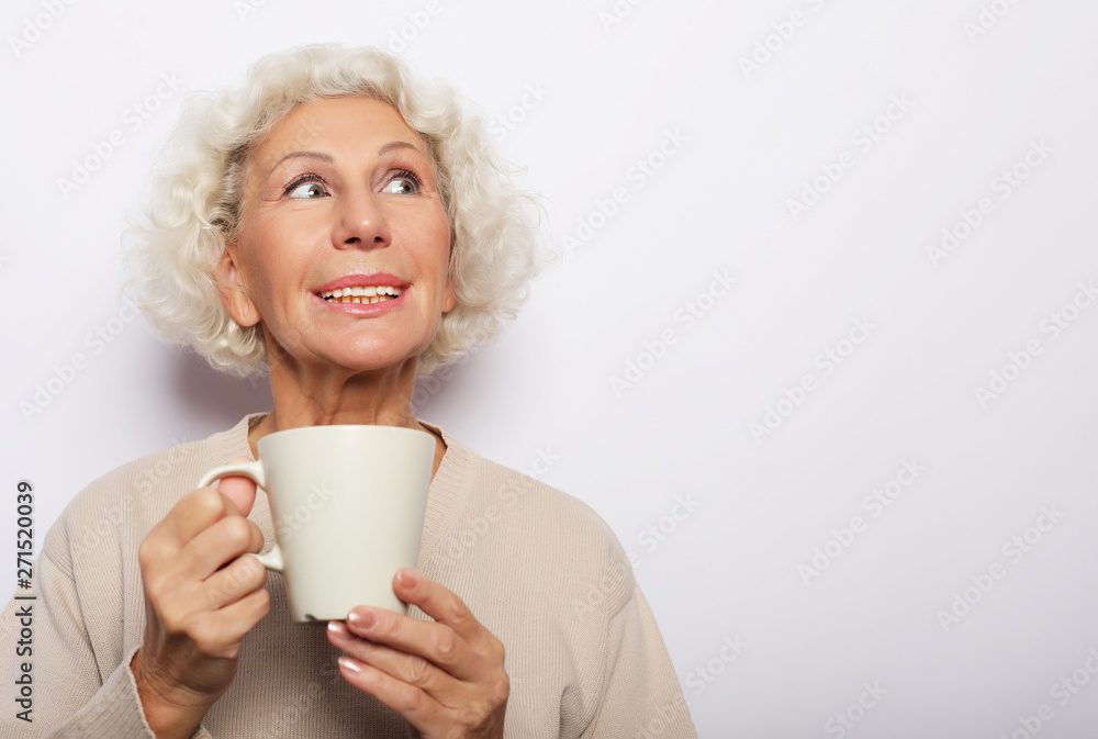 old excited lady smiling laughing, holding cup drinking coffee, tea, over white background old excited lady smiling laughing, holding cup drinking coffee, tea, over white background