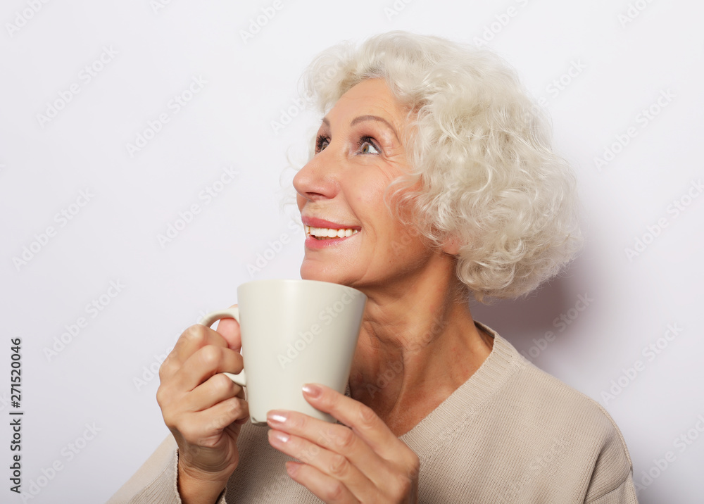 old excited lady smiling laughing, holding cup drinking coffee, tea, over white background old excited lady smiling laughing, holding cup drinking coffee, tea, over white background