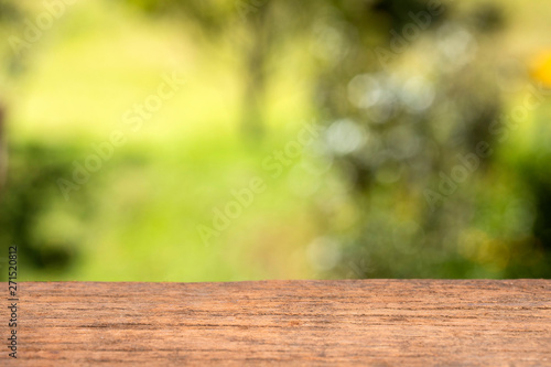 Wooden table against green blurred background. Space for design