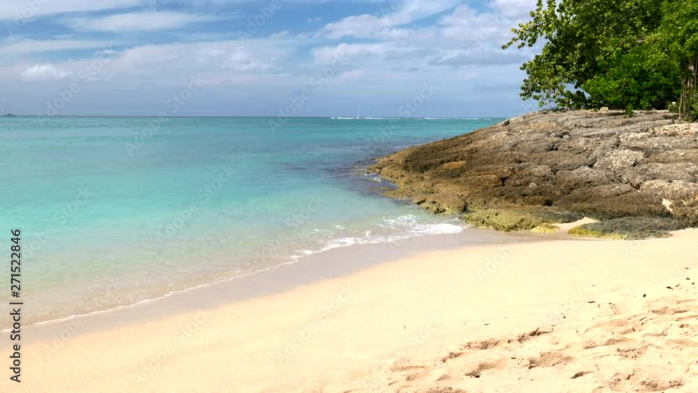 Small ocean waves wash onto the shore of a picturesque tropical beach Small ocean waves wash onto the shore of a picturesque tropical beach
