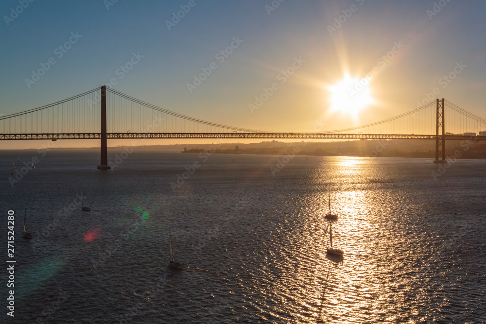 Sailboats on river with April 25th Bridge on the background at sunset
