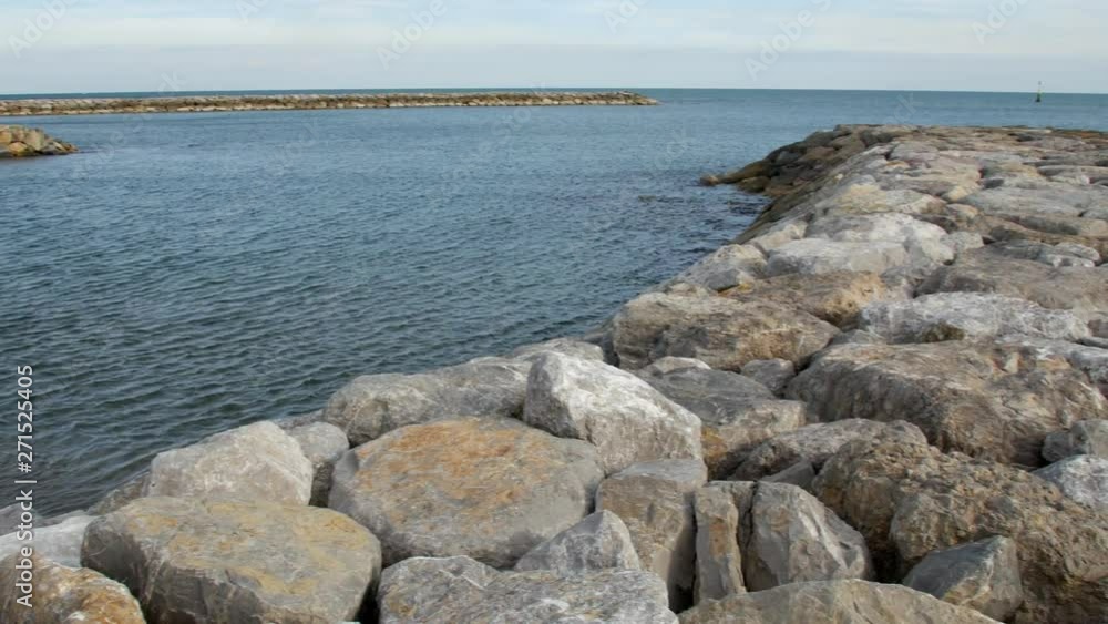 View of the breakwater of stone in the sea. Cloudy day. View of the breakwater of stone in the sea. Cloudy day.