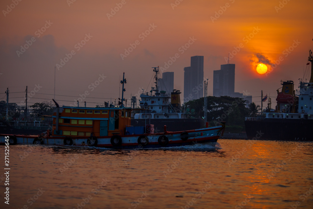 Blurred natural background of the morning sunshine along the river, breathtaking views (cargo ship, oil refinery), boat transportation
