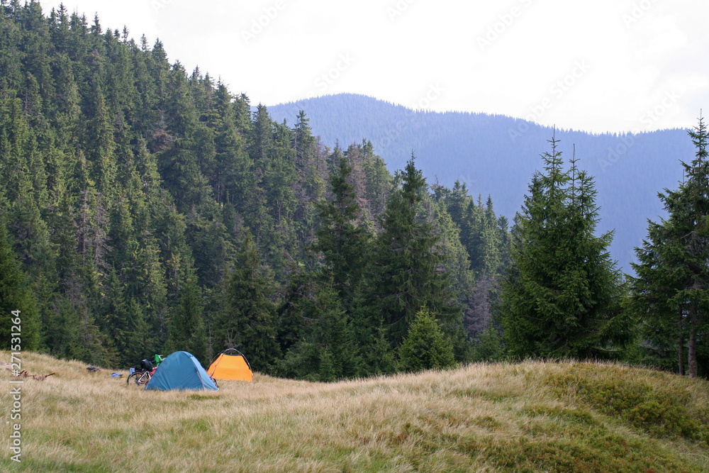 Two tents and bicycles on a meadow in the mountains