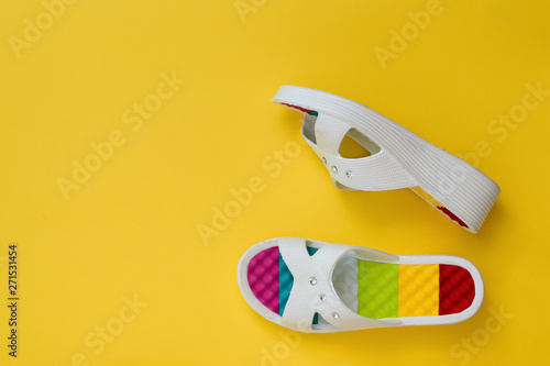 Colorful shoes for women on a bright yellow background. The concept of summer vacation. Flat lay.