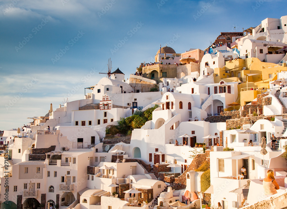 beautiful Oia town on Santorini island, Greece. Traditional white architecture and greek orthodox churches with blue domes over the Caldera, Aegean sea. Scenic travel background