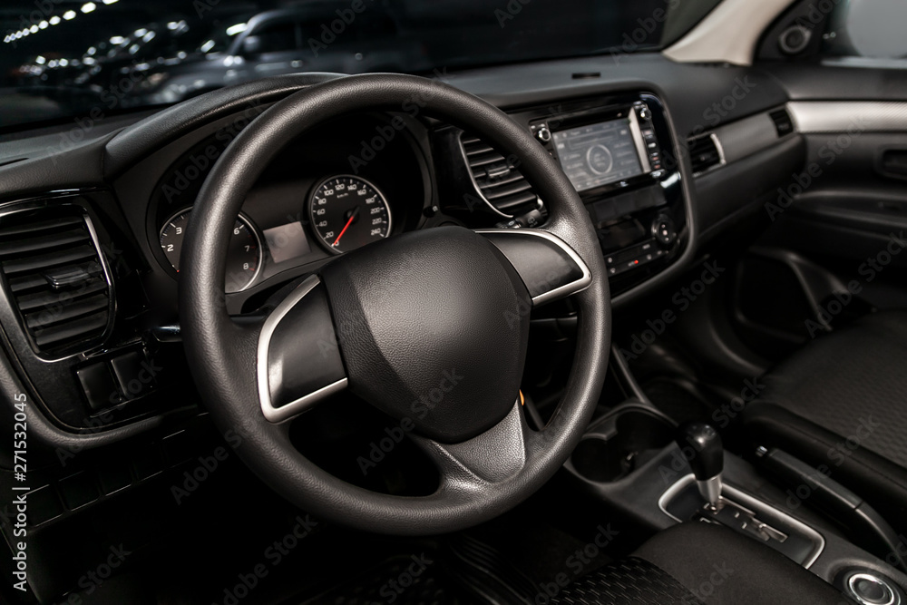 Interior view of car with black salon. Modern luxury prestige car interior:, dashboard, speedometer, tachometer  with white backlight  steering wheel  with car controller system function.