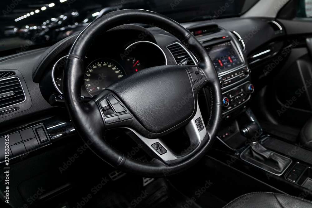 Interior view of car with black salon. Modern luxury prestige car interior:, dashboard, speedometer, tachometer  with white backlight  steering wheel  with car controller system function.