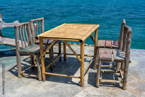Bamboo table and wooden chairs in empty cafe next to sea water in tropical beach . Island Koh Phangan, Thailand © OlegD