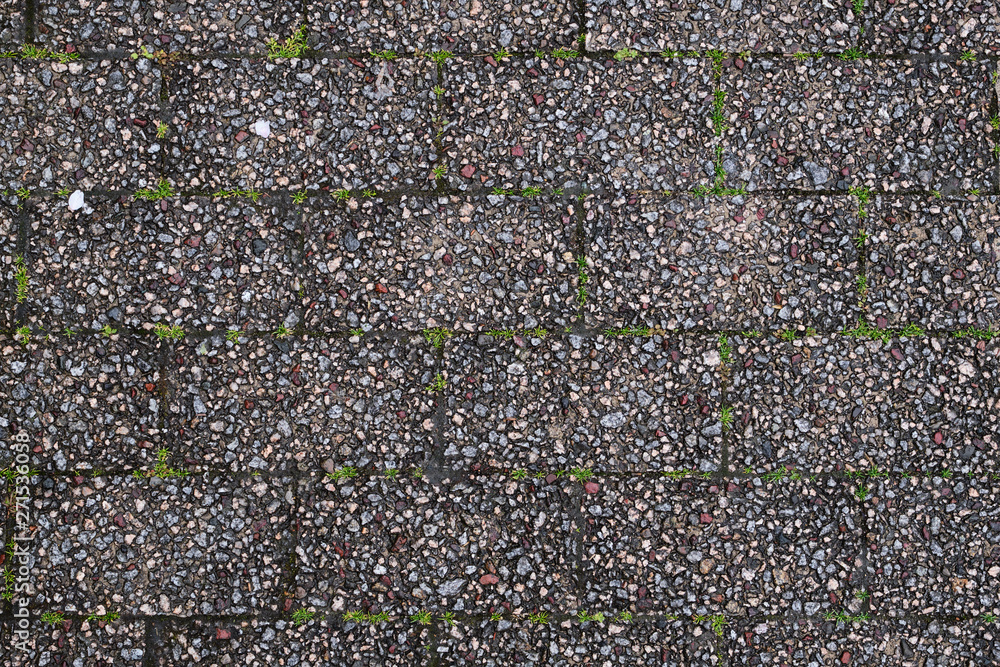 brick in gray color with gravel texture and some green of grass for background brick in gray color with gravel texture and some green of grass for background