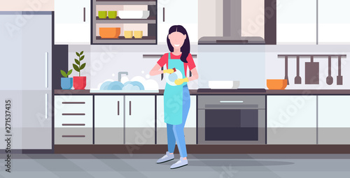 woman washing dishes housewife wiping plates with towel dishwashing concept girl in apron doing housework modern kitchen interior horizontal flat full length