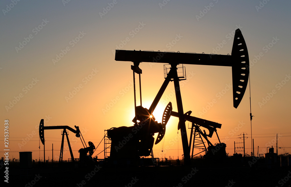 The pumping unit is working in the setting sun The pumping unit is working in the setting sun