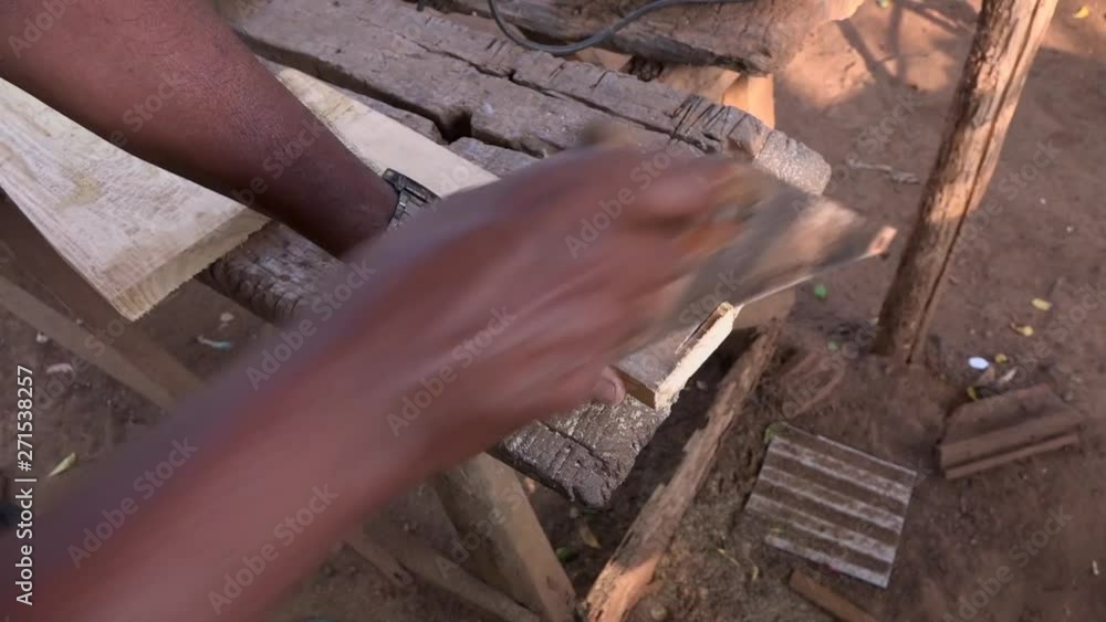 A countryside Carpenter using a hand saw to cut wood in Sri Lanka - High angle A countryside Carpenter using a hand saw to cut wood in Sri Lanka - High angle