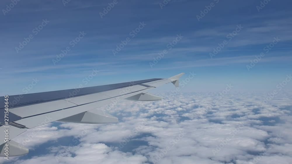 Reverse Shot View Of Almost Entire Airplane Wing Flying In A Beautiful Blue Sky Over The Clouds - 4K 60fps Reverse Shot View Of Almost Entire Airplane Wing Flying In A Beautiful Blue Sky Over The Clouds - 4K 60fps