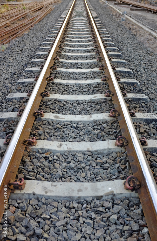 Steel support rails with concrete sleepers strewn with gravel 