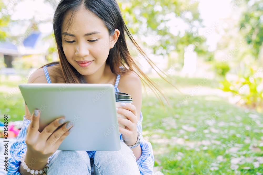 Young asian woman in casual using laptop while drinking coffee in garden with happy. Technology for life concept. Young asian woman in casual using laptop while drinking coffee in garden with happy. Technology for life concept.