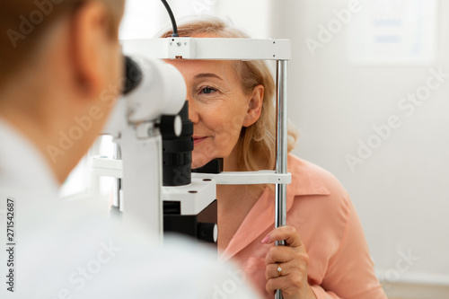 Peaceful short-haired woman listening to her doctor during appointment photo