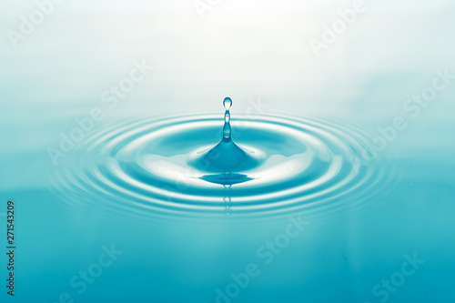 One blue drop of water on surface of water background