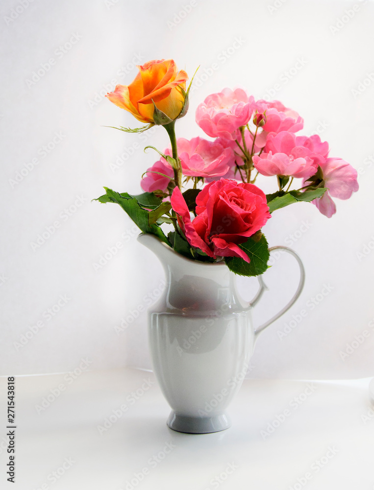 White vase with colorful flowers on a light background