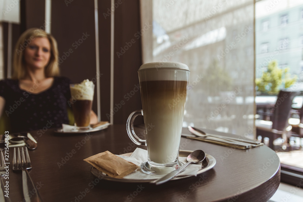 Cup of caffe latte with beauty young woman sit in coffeehouse Cup of caffe latte with beauty young woman sit in coffeehouse