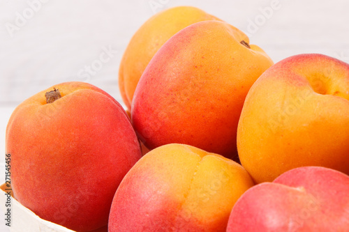Apricot or peach in wooden box as healthy snack or dessert. Food containing vitamins and minerals