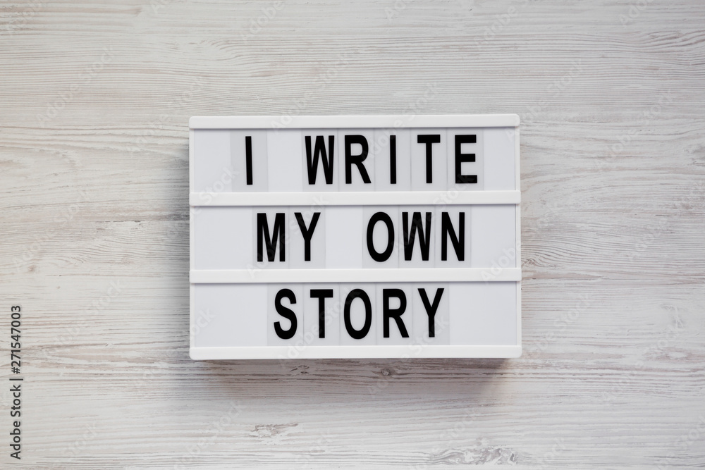 'I write my own story' words on a modern board on a white wooden surface, top view. From above, overhead, flat lay. 'I write my own story' words on a modern board on a white wooden surface, top view. From above, overhead, flat lay.