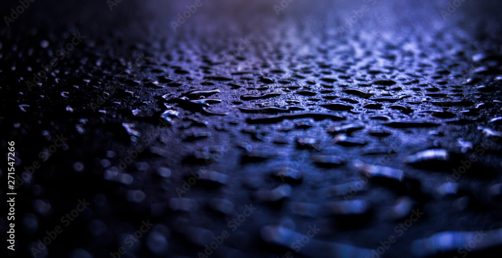 Dark background. Spilled liquid on the mirror surface, the reflection of neon lights, glare, blurred bokeh background. Neon, night view of the streets of a big city. Dark background. Spilled liquid on the mirror surface, the reflection of neon lights, glare, blurred bokeh background. Neon, night view of the streets of a big city.