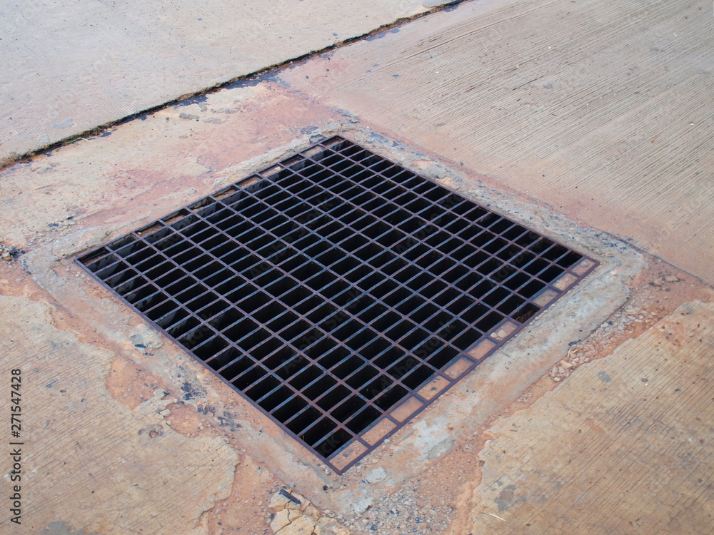 Metal grilles on the drainage system, rectangular drainage pipes and holes on the concrete floor For flood protection within the residential area of the urban community. Metal grilles on the drainage system, rectangular drainage pipes and holes on the concrete floor For flood protection within the residential area of the urban community.