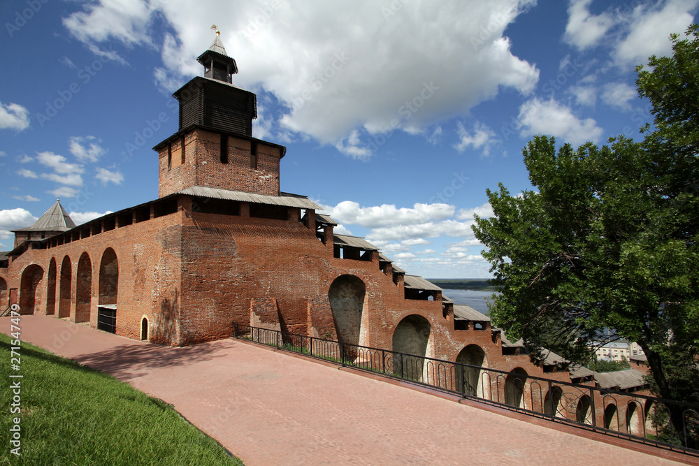 Fototapeta premium View of Clock tower and a wall of the Kremlin under the blue sky with beautiful white clouds