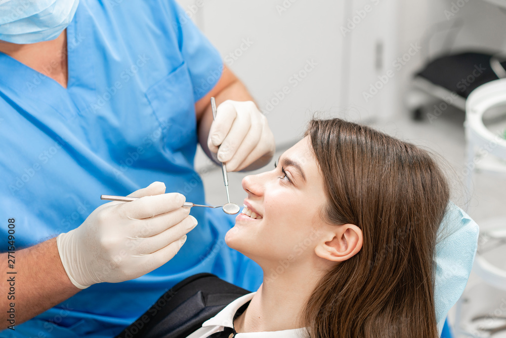 Young beautiful woman in the dentist chair at dental clinic. Medicine, health, stomatology concept. dentist treating a patient. Woman smiling Young beautiful woman in the dentist chair at dental clinic. Medicine, health, stomatology concept. dentist treating a patient. Woman smiling