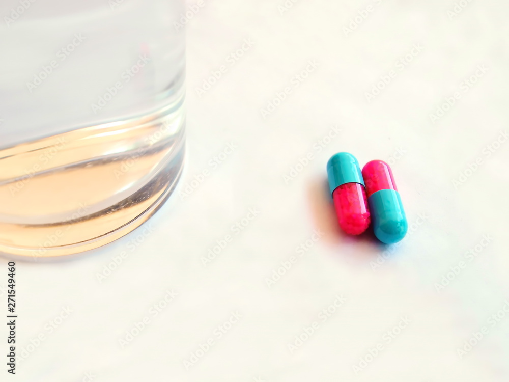 Two red and blue pill capsules, isolated on a white background On the right side of the glass With copy space. Two red and blue pill capsules, isolated on a white background On the right side of the glass With copy space.