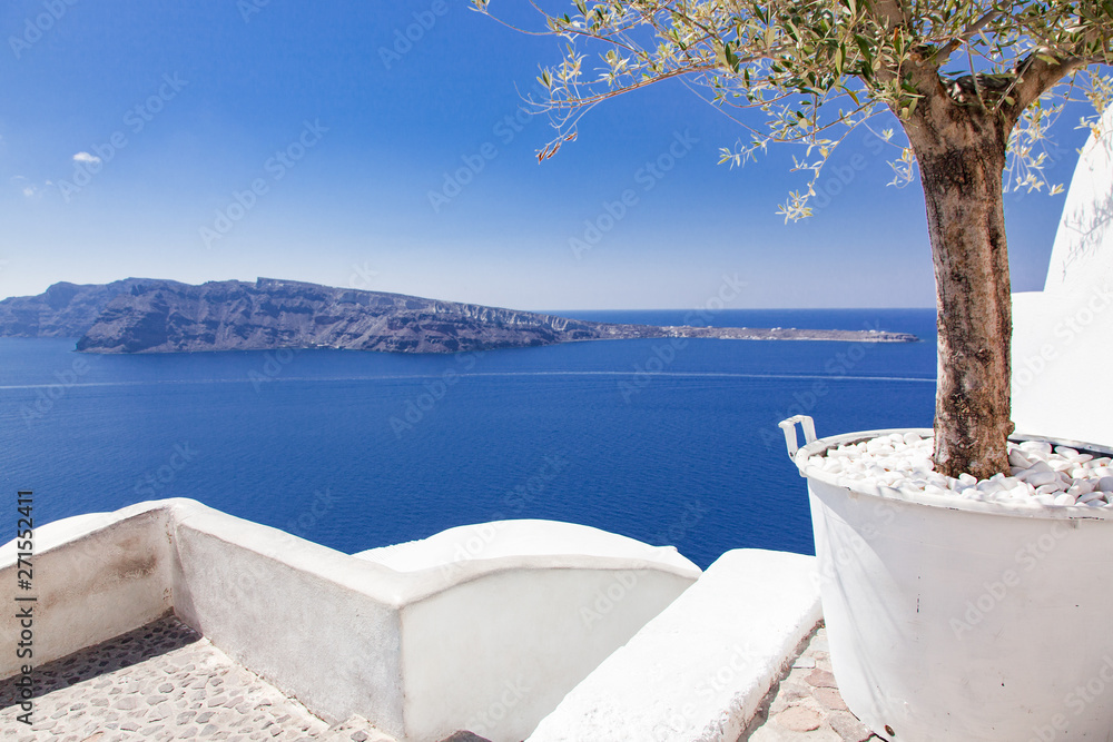 Obraz premium beautiful Oia town on Santorini island, Greece. Traditional white architecture and greek orthodox churches with blue domes over the Caldera, Aegean sea. Scenic travel background