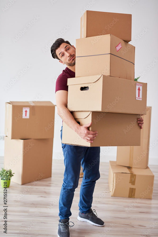 Portrait of man carrying stack of heavy cardboard boxes Portrait of man carrying stack of heavy cardboard boxes