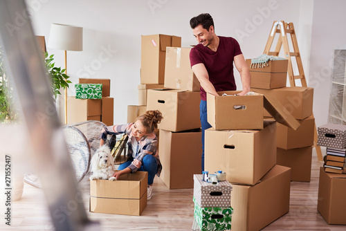 Young couple in new apartment with small dog photo