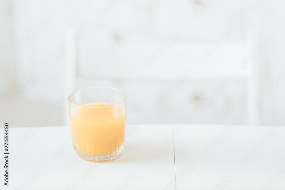 Healthy diet. Balanced nutrition breakfast. Glass of orange juice on white table in kitchen. Blur background. Copy space. Healthy diet. Balanced nutrition breakfast. Glass of orange juice on white table in kitchen. Blur background. Copy space.