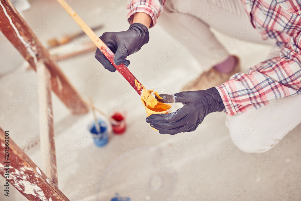 Working woman plastering / painting walls inside the house. Working woman plastering / painting walls inside the house.