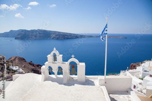 beautiful Oia town on Santorini island, Greece. Traditional white architecture and greek orthodox churches with blue domes over the Caldera, Aegean sea. Scenic travel background