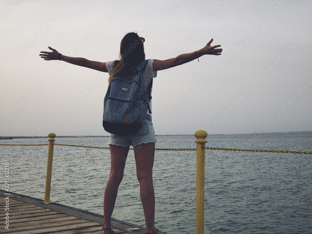 With arms wide open on a tropical / ocean scenery. With arms wide open on a tropical / ocean scenery.