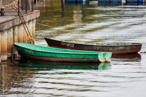 Beautiful water view on a cloudy day in a small port city with boats and bridge.