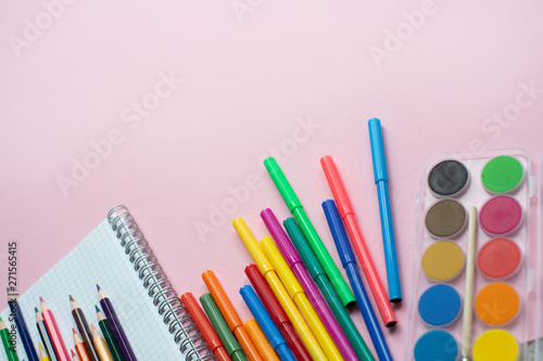 School supplies lay on pink background, back to school concept, copy space