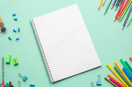 School supplies color background flat lay on green background, back to school concept, copy space, vertical