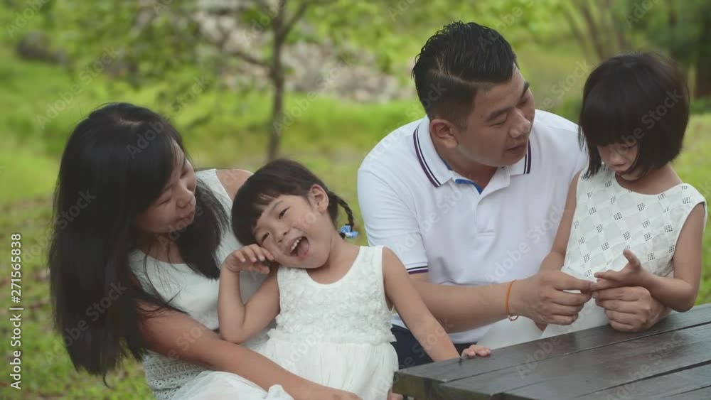 Happy Asian Family enjoying their time in the park Happy Asian Family enjoying their time in the park