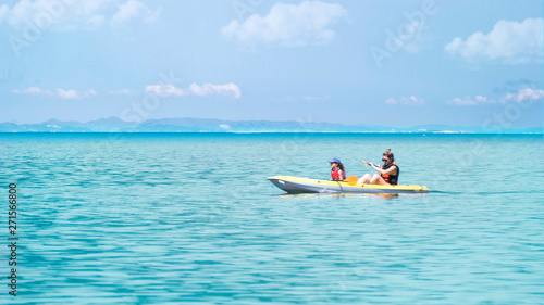 Happy family canoeing in a kayak smiling on holidays. Adventure travel with empty copy space for Editor's text.