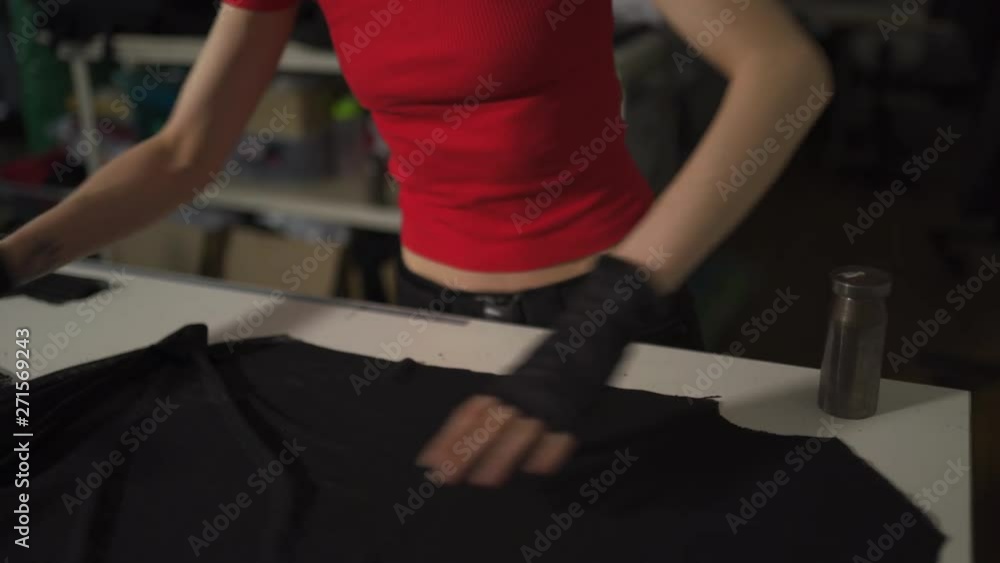 Cyber punk fashion designer at work in her studio cutting pattern - Caucasian white woman wearing red t-shirt and black gloves with scissors hanging over her chest Cyber punk fashion designer at work in her studio cutting pattern - Caucasian white woman wearing red t-shirt and black gloves with scissors hanging over her chest
