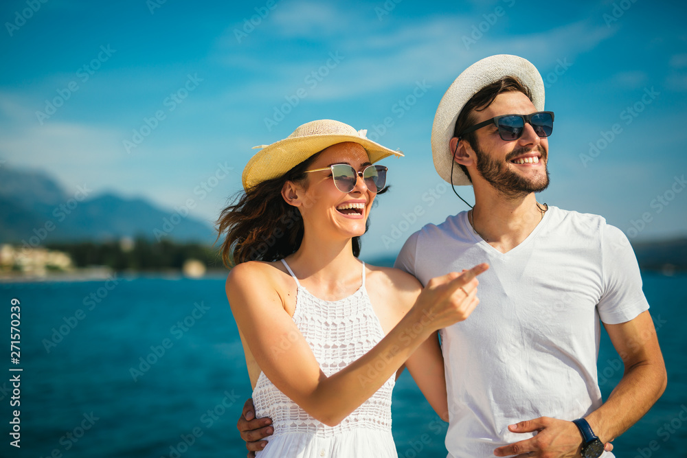 Young beautiful tourist couple enjoying summer holiday on the seaside Young beautiful tourist couple enjoying summer holiday on the seaside