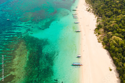 Puka Shell Beach. Wide tropical beach with white sand. Beautiful white beach and azure water on Boracay island, Philippines, top view. Tourists relax on the beach.