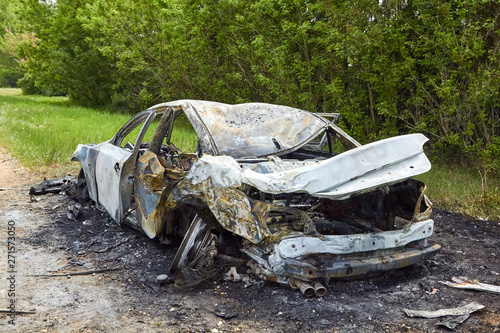 Canvas Print Fully burned car on roadside after collision with heavy truck