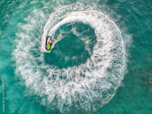 People are playing a jet ski in the sea.Aerial view. Top view.amazing nature background.The color of the water and beautifully bright. Fresh freedom. Adventure day.clear turquoise at tropical beach. © MAGNIFIER