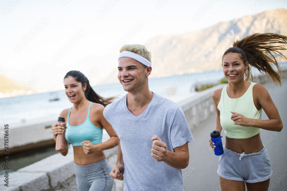 Happy fit people running and jogging together in summer sunny nature Happy fit people running and jogging together in summer sunny nature